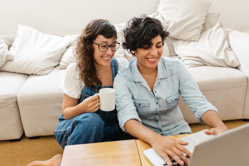 Lesbian couple at home with laptop