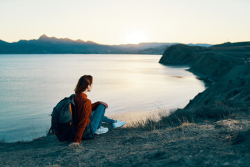 woman on vacation resting in the mountains near the sea at sunset