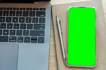 keyboard laptop computer,smartphone Green screen on notebook,Mechanical pencil and coffee cup on wooden background