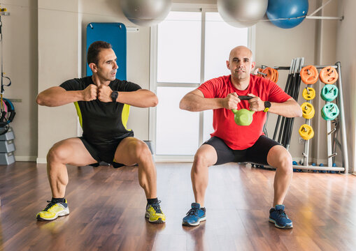 Coach with a man exercising with a kettlebell