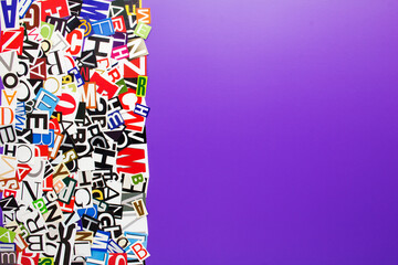 Fototapeta na wymiar Alphabet letters cutting from paper magazine on purple background with copy space for text. Abstract collage from clippings with newspaper magazine letters.