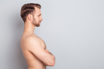 Profile side view portrait of attractive fit sportive man folded arms copy blank space ad isolated over grey pastel color background