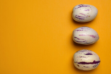 Fresh ripe pepino melons on orange background, flat lay. Space for text