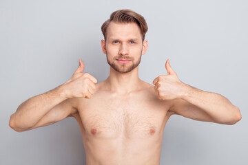Photo of adorable sweet blond hair young guy no clothes smiling showing two thumbs up isolated grey color background