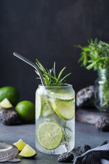 Hard seltzer cocktail with lime, rosemary and bartenders accessories