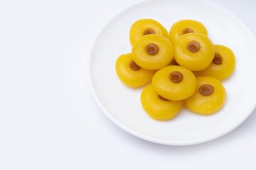 Kanom Sanay Chan, traditional sweet dessert originating in Thailand - Nutmeg –like yellow sweetmeats, serving on white plate isolated on white