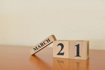 March 21, Date design with calendar cube on wooden table and white background.
