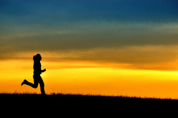 Silhouette of girl running in sunset