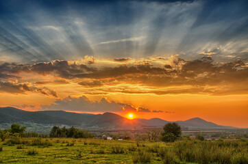 Sunset with rays scattering in the clouds