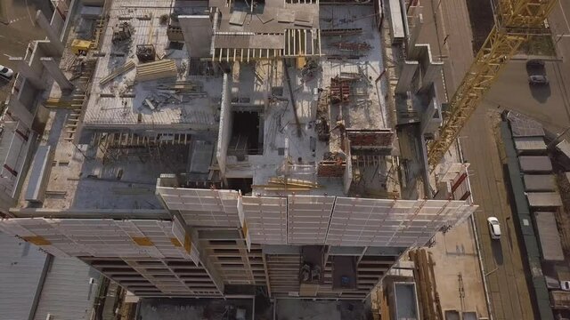 The camera descends on a house under construction with working builders and a crane Ukraine Kiev obolon 2021 May 11