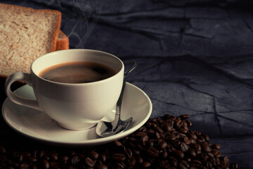 Hot espresso coffee with bread on dark background.