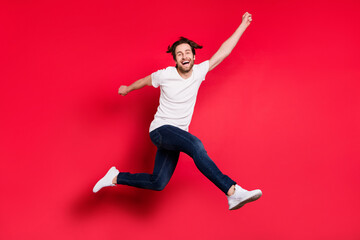 Fototapeta na wymiar Full length profile side photo of young guy happy positive smile rejoice victory success go walk jump isolated over red color background