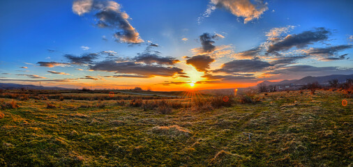 Colorful spring sunset with Sun rays coloring the clouds