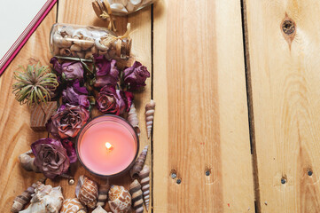 Overhead image of a pink candle and dried roses