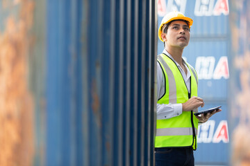 factory worker or engineer using tablet for preparing a job and looking something in containers...