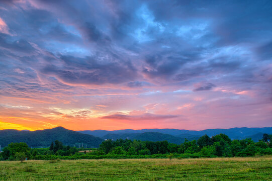 Colorful autumn sunset with sun rays coloring the clouds