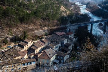 Fototapeta premium Aerial view of the french Pontaix village with old stone houses and the Drome river under evening light.