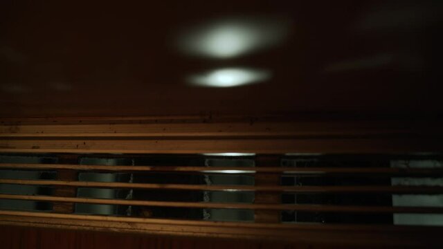 View through the dirty, dusty, old metal lattice of the elevator to the lamps in the elevator shaft. Old retro elevator moving up, close-up