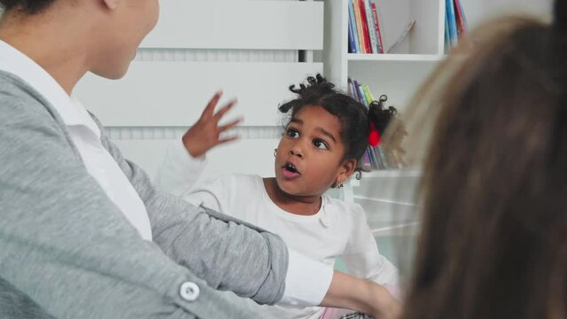 Smiling Kids Telling A Story To The Teacher.