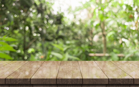 Empty wooden table top and green nature bokeh for display product.