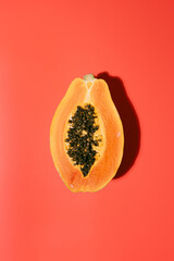 Fresh papaya with black seeds on a red background in summer. holiday and nature concept. copy space. top view