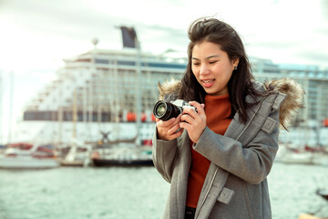asian female traveller hand hold smartphone taking photo of cruise ship near cruise port with clear...