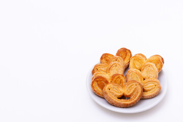 Freshly cooked heart shaped cookies on a white background, copy space. Morning breakfast for loved ones