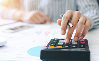 woman accountant doing finance and calculate on a desk about cost at the home office. finance accounting concept - obrazy, fototapety, plakaty