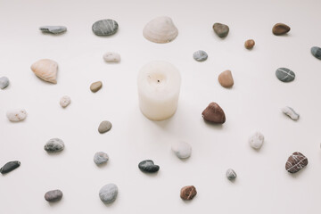 White candle and sea shells pattern on white background. Spa concept. Flat lay, top view