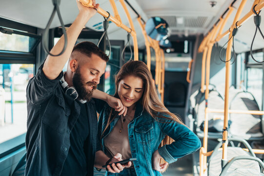 Young couple standing in a moving bus