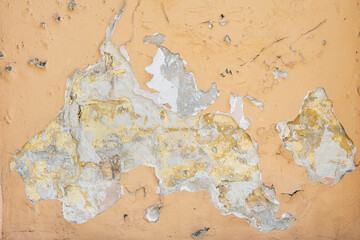 Orange Wall with cracked paint. Background for creative projects. Cracked wall with old layers of paint in abandoned house. Abstract orange Horizontal Empty Wallpaper..