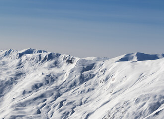 Fototapeta na wymiar View on off-piste snowy sunlight slope at sun winter evening