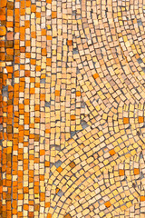 Background of ancient orange ceramic mosaic. A wall with a Colorful textured surface, vertical shot..