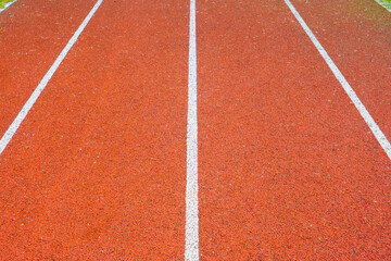 White symmetrical lines of the red running track, leading to the front. Straight running track lines of the athletic field. Sport background.