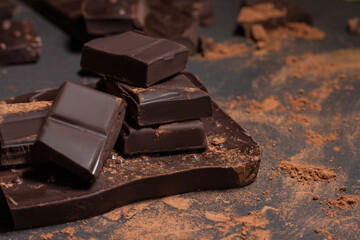 Chocolate with cocoa close up powder on grey background