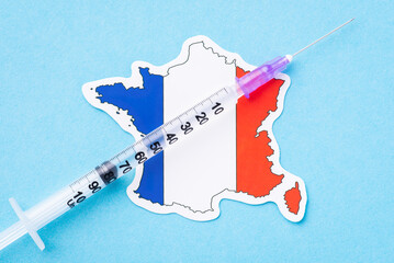 France vaccination. Syringe with liquid substance on flag of France
