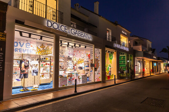 Marbella, SPAIN - July 16 2020: Night photography in luxury and famous location of Marbella - Puerto Banus Bay. View of Dolce and Gabbana Store , in the shopping area of the harbour. Empty street