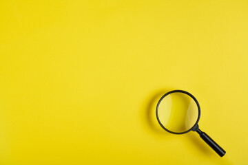 Magnifying glass on yellow background - obrazy, fototapety, plakaty
