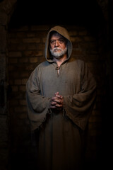 poor medieval monk stands in the monastery pensive