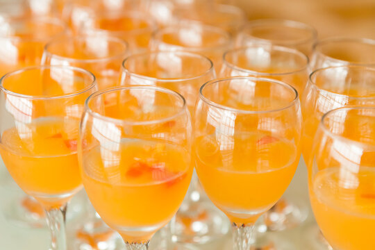 At the banquet, orange cocktails are arranged closely on the table
