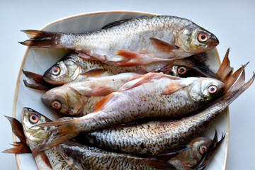 Peeled fresh river fish in a plate in the kitchen