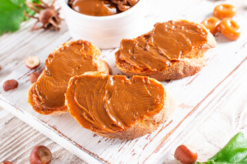 Slices of bread with chocolate nut cream or boiled condensed milk on a cutting board