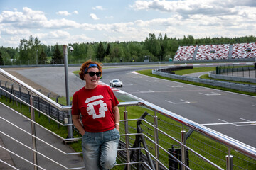 woman cheerleader in a red t-shirt at the circuit at the sports sports car races 