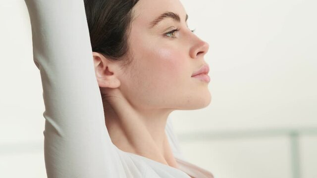 The side view of a woman pulling her arms up