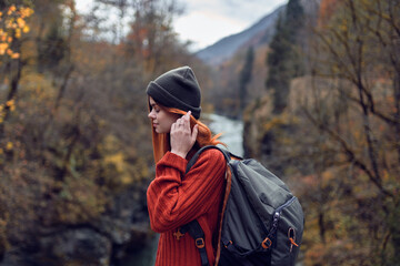 woman hiker in the autumn forest on the bridge near the river travel