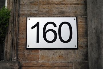 Metal Plate with Number 160 on Old Stone Wall beside Building Entrance 