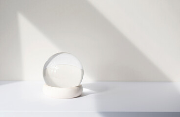 Minimal composition with glass ball on white desk, glass globe ball as decoration of interior....