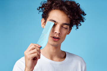 handsome guy with curly hair on a blue background portrait close-up tangled curls