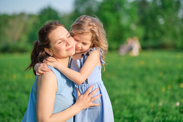Naklejka premium nature scene with family outdoor lifestyle. Mother and little daughter playing together in a park. Happy family concept. Happiness and harmony in family life.