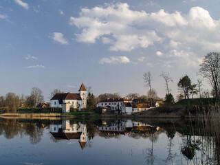 Fototapeta na wymiar Alsunga catholic church and reflection in lake, Latvia. 